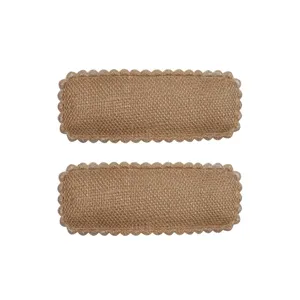 Detail of cute brown woven burlap hair clips with scalloped edges for young girls