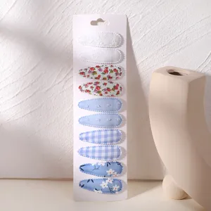 Detail view of floral and plaid fabric teardrop hair clip set on display card