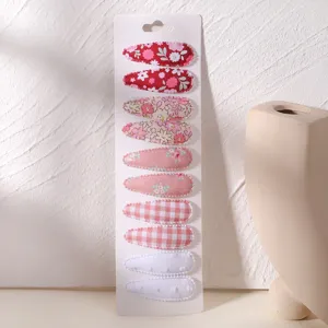 Detailed view of floral and plaid fabric snap hair clip set on display card