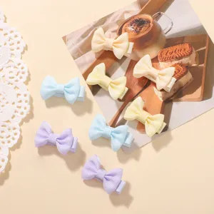 Pinzas de pelo con lazo de cinta en colores pastel para niñas sobre fondo decorativo