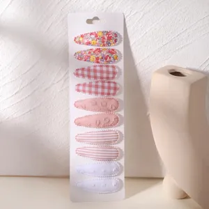 Set of 10 floral and plaid fabric BB hair clips for girls presented on display card