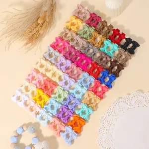 Detalle de un conjunto colorido de mini pinzas para el cabello con lazo para niñas.