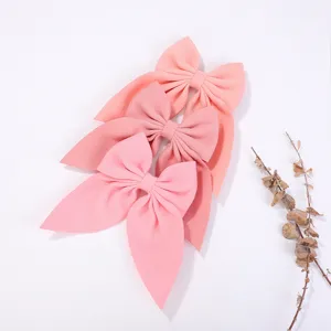 Primo piano di graziosi fermagli per capelli con fiocco in tessuto rosa, accessori eleganti.
