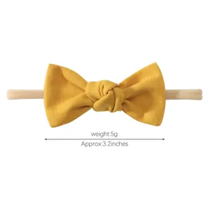 Detail view of a soft yellow bow headband for baby girls with size and weight info