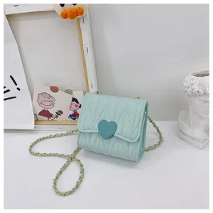Detailed view of mint green quilted child's purse with heart clasp and chain strap.