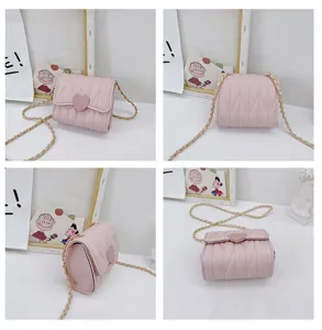 Detailed views of a mini pink quilted crossbody bag with heart decor and chain strap