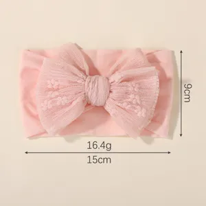 Close-up of pink baby bow headband showing dimensions 15cm by 9cm and 16.4g weight