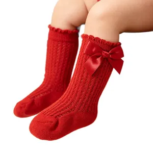 Süße rote Kniestrümpfe für Babys mit großer Satinschleife und dekorativem Lochmuster