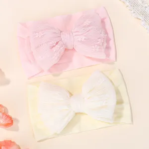 Soft infant baby headbands featuring large pleated lace bows in pink and cream colors