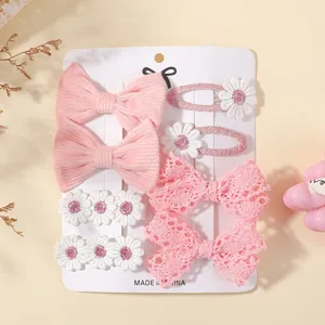 Detalle de pinzas para el cabello rosas con lazos de encaje y motivos de flores blancas