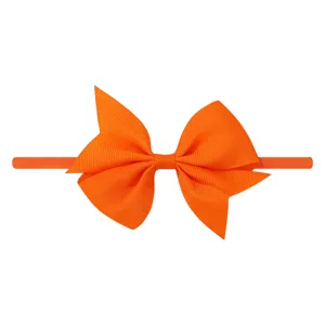 Bandeau élastique orange pour bébé avec un grand nœud en ruban gros-grain sur fond blanc