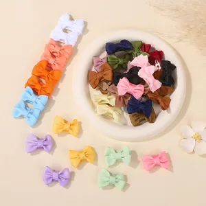 Detailed view of colorful grosgrain ribbon bow hair clips for kids on a white decorative plate