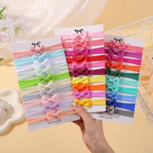 Detailed close-up of 30 assorted colorful elastic nylon bow headbands for infants and babies
