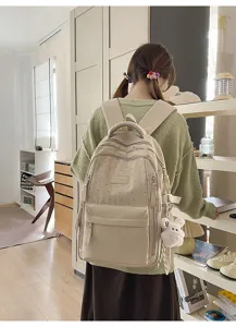 Rückansicht eines Mädchens mit einem cremefarbenen Rucksack mit Sternmuster und Hasenanhänger