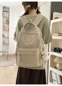 Detailansicht eines beigen Sternenrucksacks, getragen von einer Schülerin in einem Zimmer