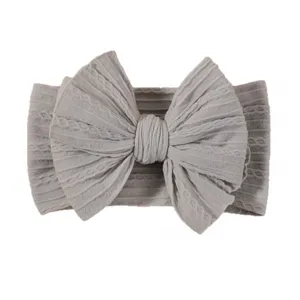 Soft grey elastic baby headband with a large textured jacquard bow design.