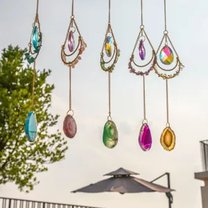 Suncatcher vari con agata naturale e prismi di cristallo appesi in un bellissimo giardino