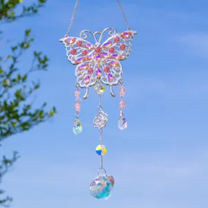 Detailed view of a butterfly suncatcher featuring pink crystals and a faceted glass ball.