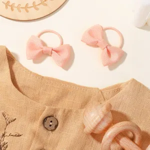 Dettaglio ravvicinato di due elastici per capelli con fiocco rosa per bambine e neonati