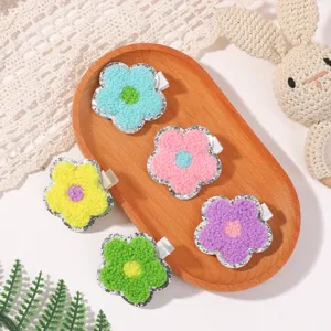 Detail view of colorful towel-embroidered flower hair clips with glitter borders