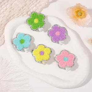 Close-up of 5 colorful embroidered flower hair clips with textured towel embroidery