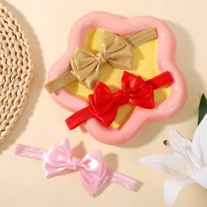 Vue détaillée de bandeaux pour bébé faits main avec nœuds en satin, couleurs vives