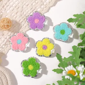 Close-up of five colorful flower hair clips with soft towel embroidery and glitter