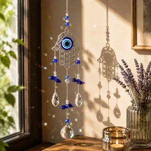 Vista dettagliata dell'acchiappasole Mano di Fatima con occhio blu e prismi di cristallo