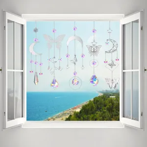 Set of five crystal suncatchers with butterfly and moon motifs hanging in an open window.