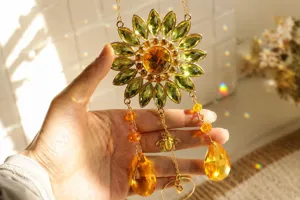 Detail of crystal sunflower suncatcher with bee charm creating rainbow light spots.