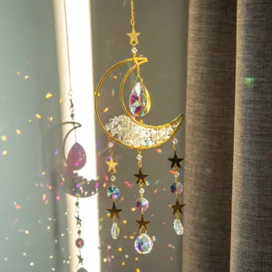 Dettaglio dell'acchiappasole a luna d'oro con riflessi di luce arcobaleno sul muro