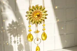 Close-up of yellow sunflower crystal suncatcher reflecting rainbow light on white wall