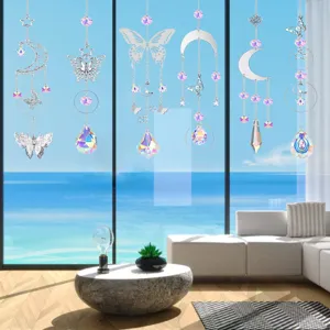 Set of variety crystal suncatchers with butterfly and moon motifs hanging by window.
