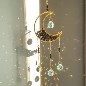 Primo piano di un acchiappasole a luna in cristallo con riflessi arcobaleno vivi