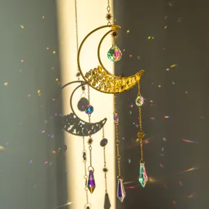 Dettaglio di un acchiappasole a luna dorata che crea vivaci rifrazioni di luce arcobaleno