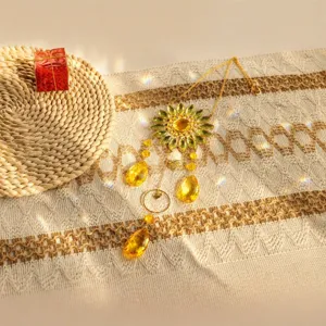 Yellow crystal sunflower suncatcher creating rainbow light spots on textured fabric