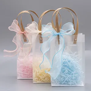 Bolsa de regalo transparente de PVC con asa de papel y lazo elegante para bodas.