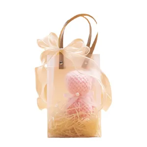 Pequeña bolsa de regalo de PVC mate con osito de ganchillo rosa, detalle de boda perfecto.
