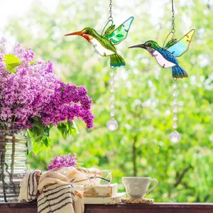 Detailed view of colorful hummingbird crystal suncatchers in a vibrant garden