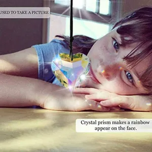 Crystal heart suncatcher prism creating rainbow reflections on a girl's face