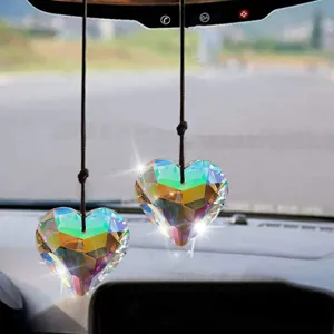 Close-up of rainbow heart crystal suncatchers hanging as car interior decoration