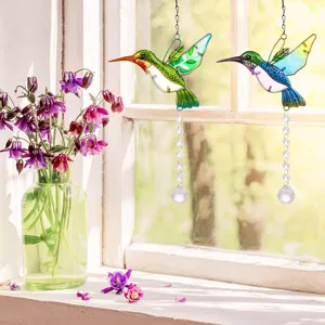 Colorful hummingbird crystal suncatchers hanging by a sunny window for garden decor.
