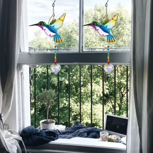Acchiappasole in cristallo a forma di colibrì appeso a una finestra sul giardino