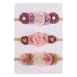 Set van drie delicate babybloemenhoofdbanden met zachte elastische banden en stoffen bloemen