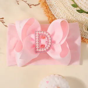Mignon bandeau rose pour bébé avec un grand nœud et une lettre D ornée de perles et strass