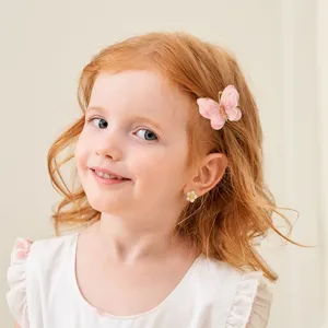Lindo pasador de mariposa rosa usado por una niña pequeña, accesorio de cabello elegante.