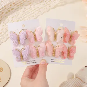 Detalle de un conjunto de pinzas para el cabello con mariposas en una tarjeta blanca