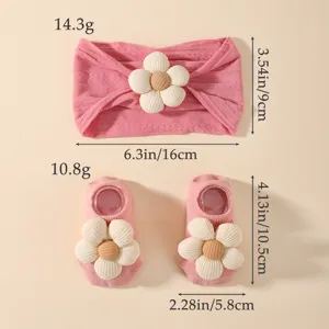 Detailansicht der Maße von rosa Baby-Stirnband und Socken mit floralem Dekor