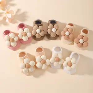 Fünf Paar pastellfarbene Babysocken mit großen Cordblumen-Verzierungen im Set.
