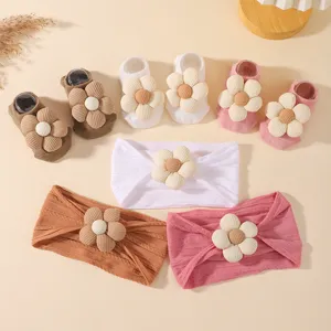 Detail des Baby-Stirnband- und Sockensets mit großen 3D-Blumendekorationen in verschiedenen Farben